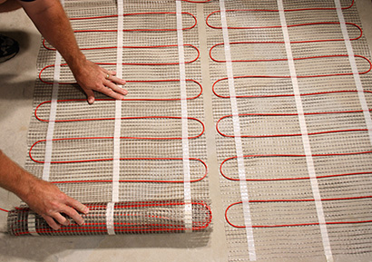 Line voltage floor heating mats being installed.